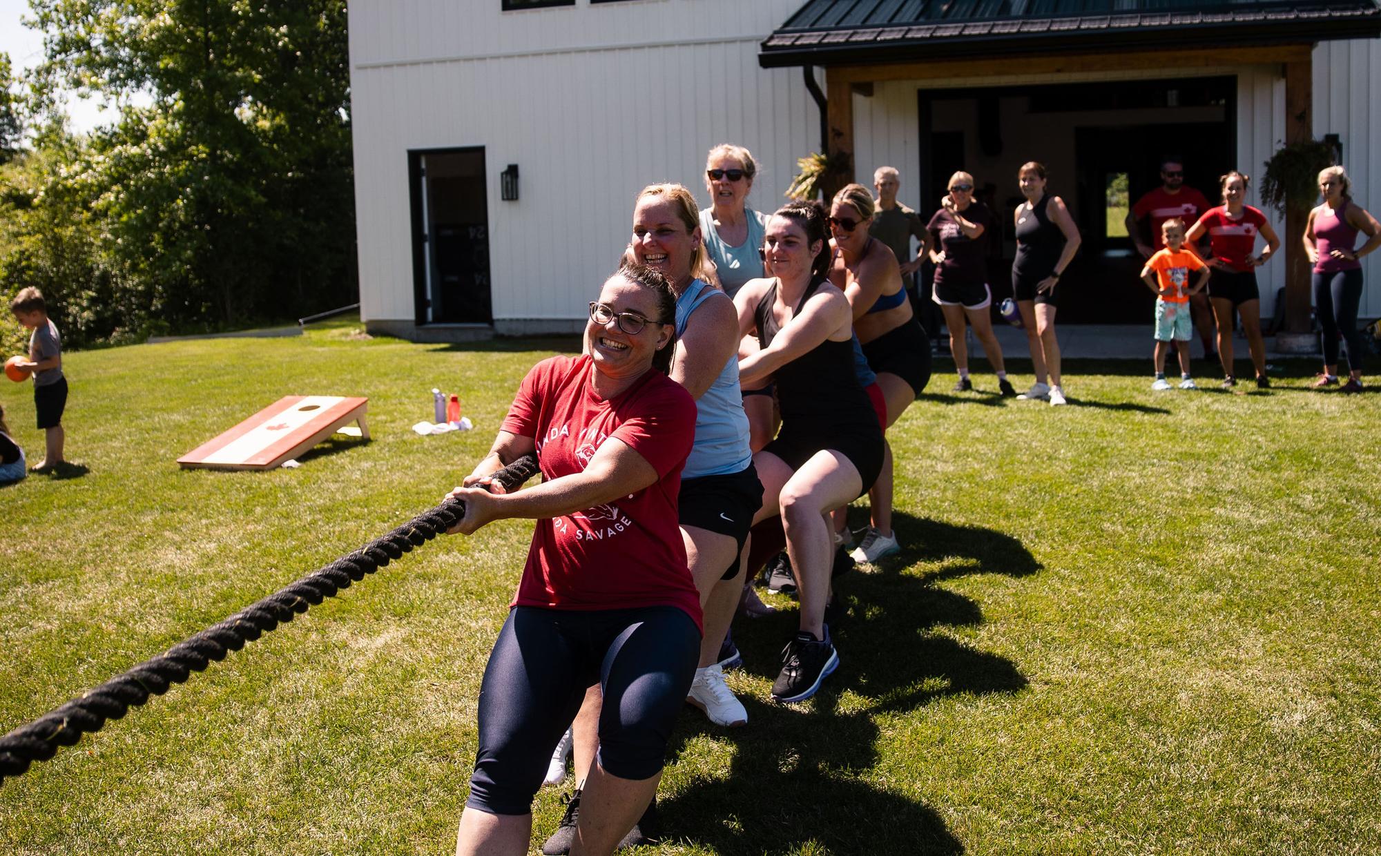 Members pulling together in a tug of war on the lawn outside The Yard